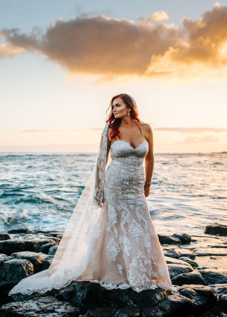 bride posing on the rocks at sunset