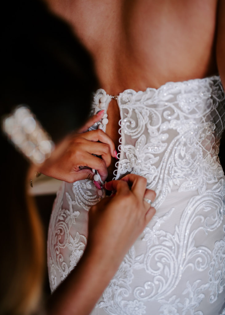 brides best friend zipping up her dress