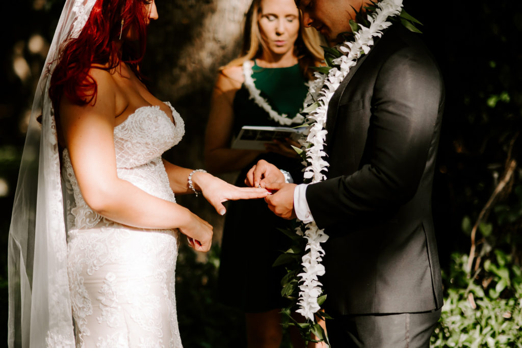 groom putting ring on brides finger