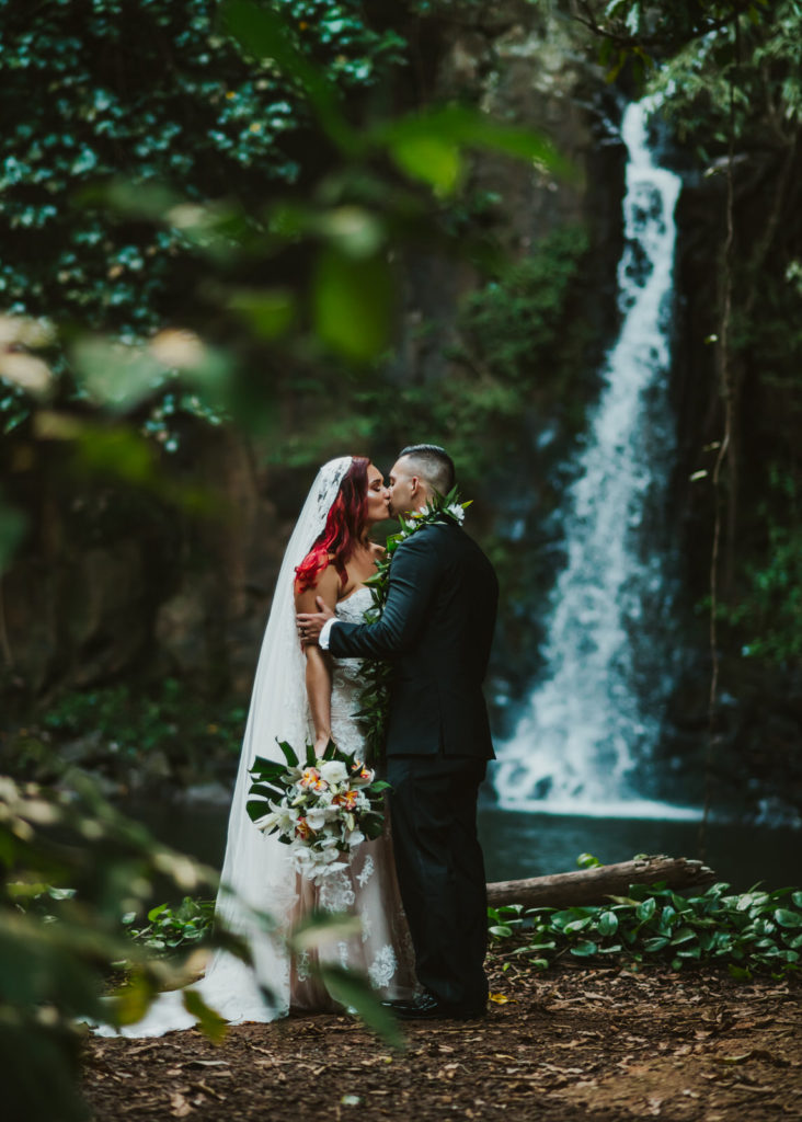 pulled back shot of couple in front of the waterfall
