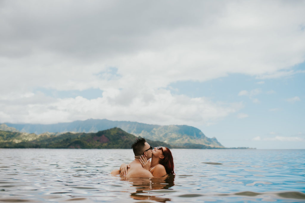 couple kissing in the water near hanalei bay