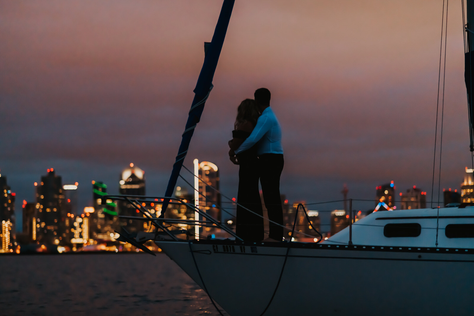 couple on a sail boat overlooking the san diego coast line