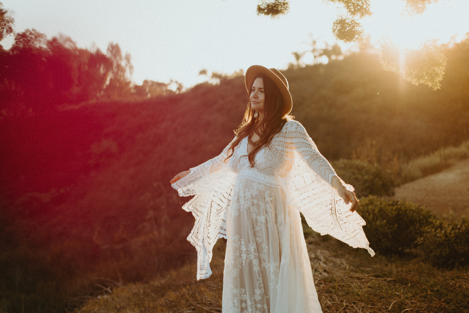 woman in boho maternity dress for photoshoot at sunset